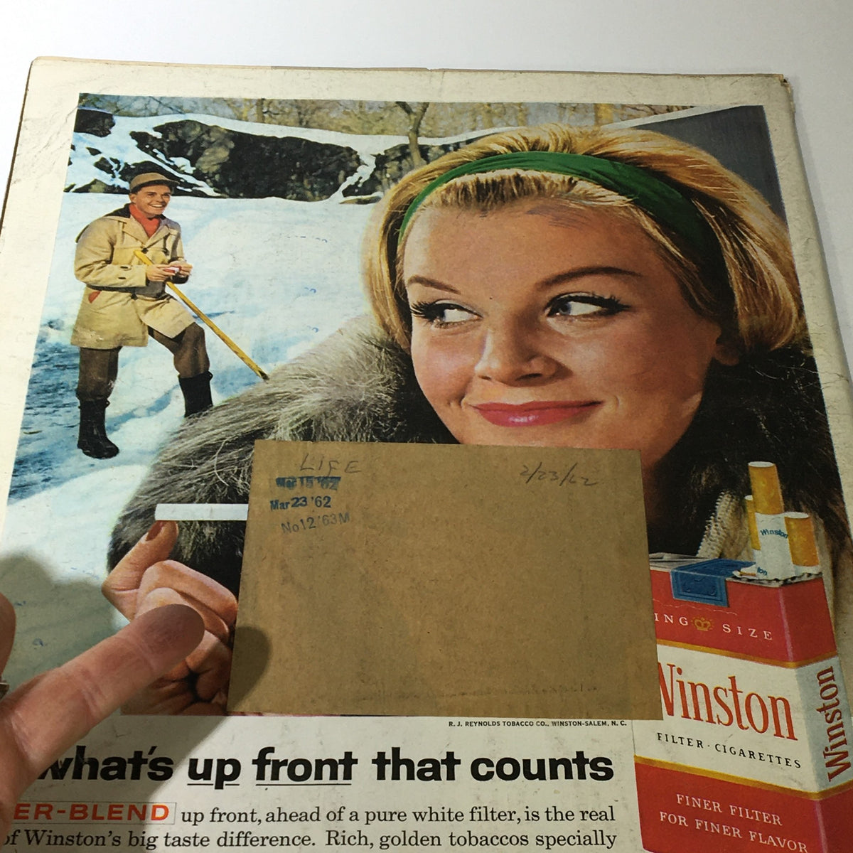 VTG Life Magazine February 23 1962 back cover displaying a charming winter scene with a smiling woman and a man in winter attire, highlighting nostalgic advertising elements.
