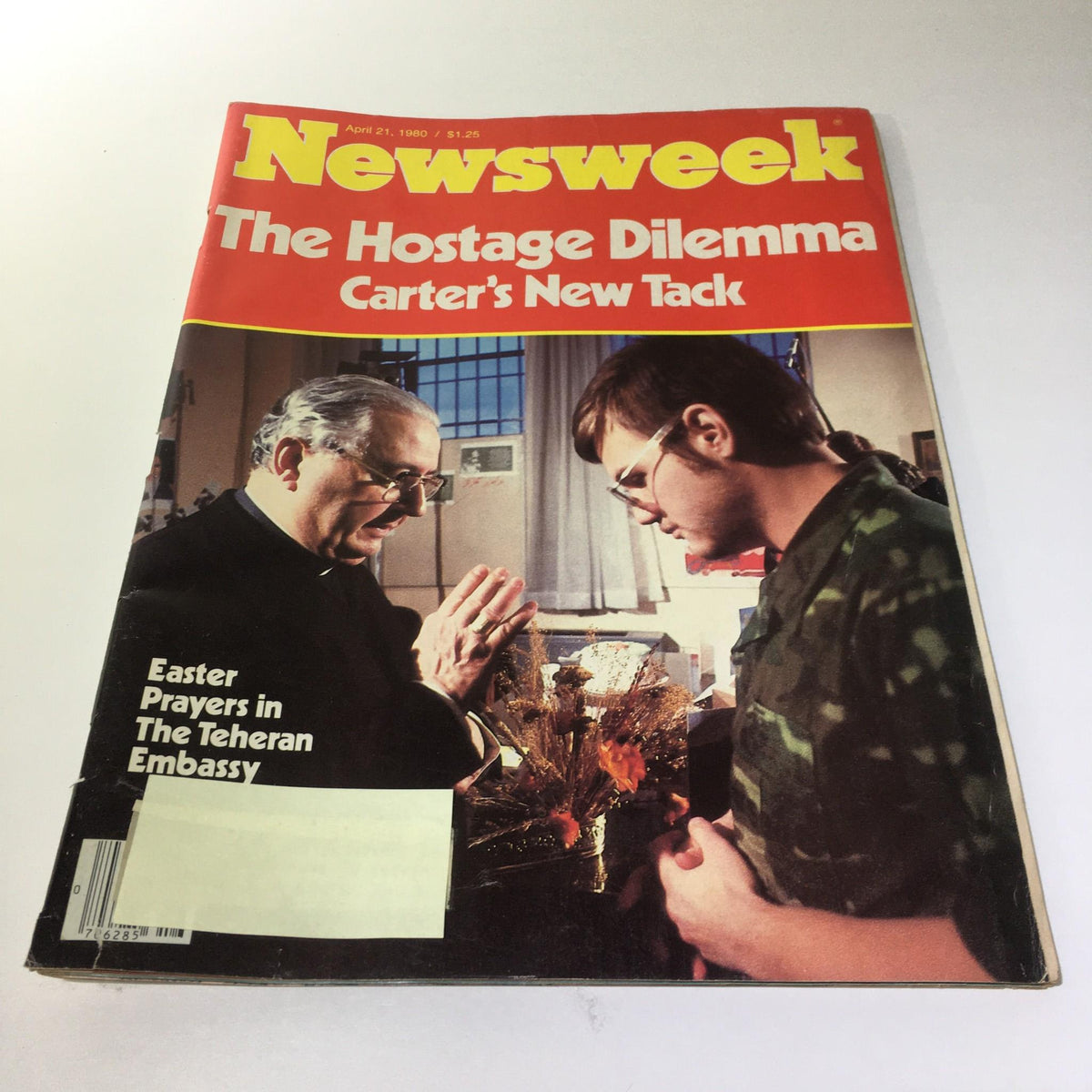 Newsweek Magazine: April 21, 1980 cover featuring the title 'The Hostage Dilemma: Carter's New Tack' with a photograph of a man in military attire standing beside an older man in prayer. This vintage magazine captures a pivotal moment in U.S. history related to the hostage crisis.