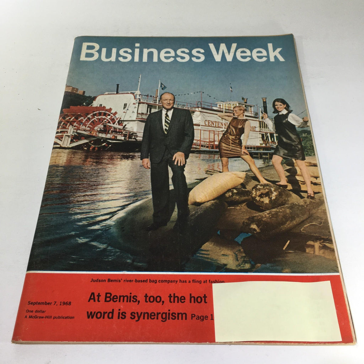 Business Week Magazine cover from September 7, 1968, featuring the headline 'The Hot Word Is Synergism'. The image shows a businessman in a suit standing on the riverbank with two women in fashionable outfits nearby, along with a riverboat in the background.
