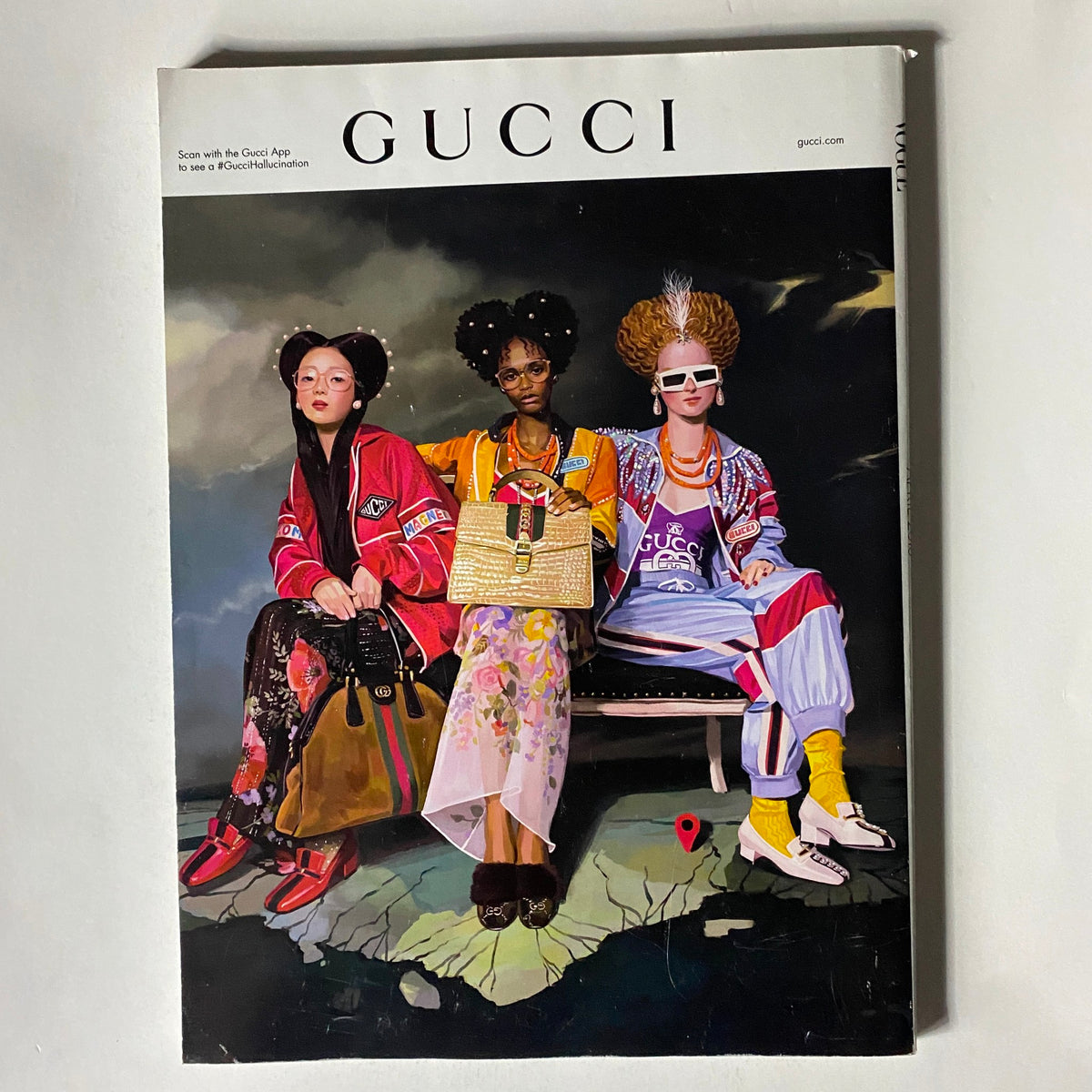 Cover of Gucci magazine showcasing three models in eclectic outfits, highlighting the vibrant and bold fashion statements akin to the style of Vogue Magazine April 2018.
