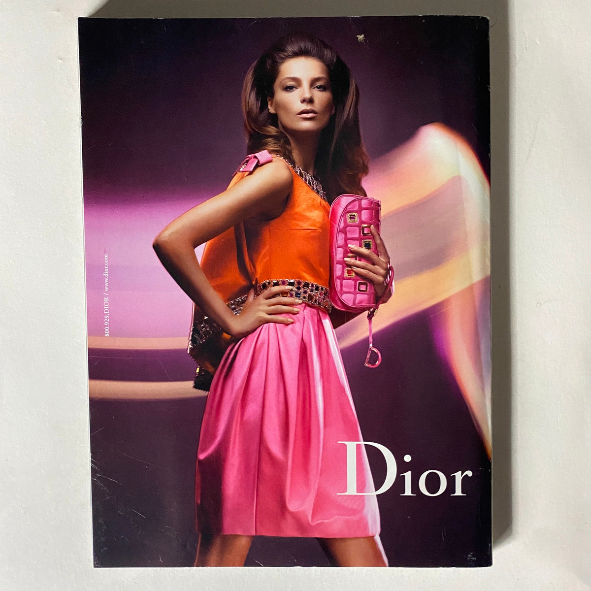 Fashion advertisement for Dior in Harper's Bazaar Magazine October 2008, featuring a model in vibrant clothing and a stylish handbag.