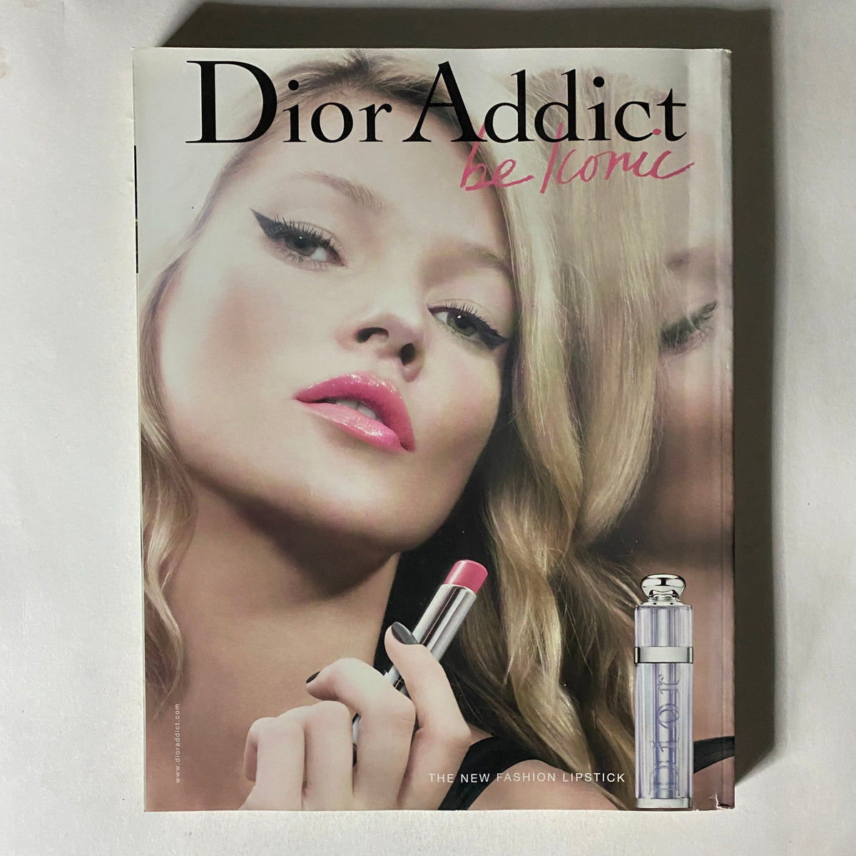 Dior Addict promotional cover featuring a stylish model showcasing lipstick, representing fashion and beauty trends.