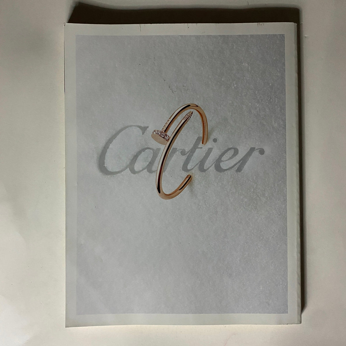 Cartier advertisement featuring a close-up image of a delicate gold bracelet, symbolizing luxury and elegance, from the Vogue UK Magazine January 2018 issue.