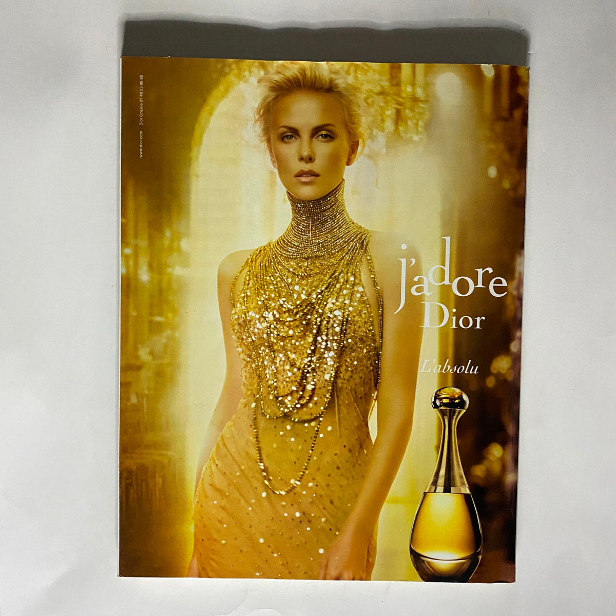 Promotional advertisement for Dior's J'adore fragrance, featuring a glamorous model in gold attire, part of the Vogue Paris Magazine December 2012 issue.
