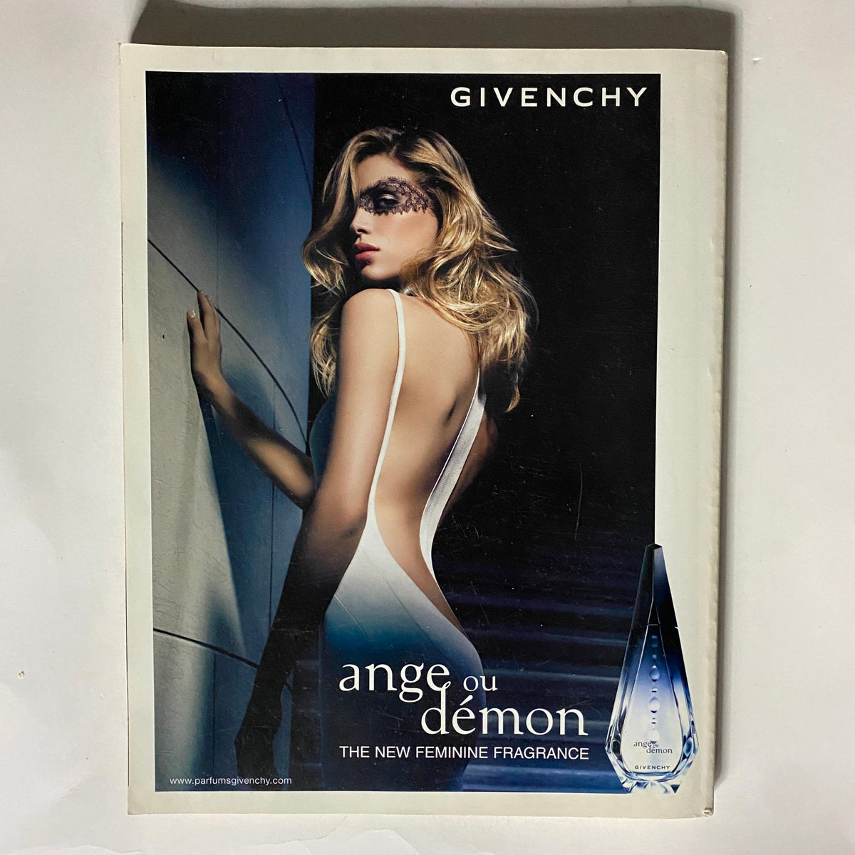 Cover of a Givenchy advertisement featuring a glamorous model showcasing 'Ange ou Démon' fragrance. The model is portrayed in an elegant dress, emphasizing allure and luxury, underscoring the essence of the Vogue UK Magazine June 2007 featuring Agyness Deyn.