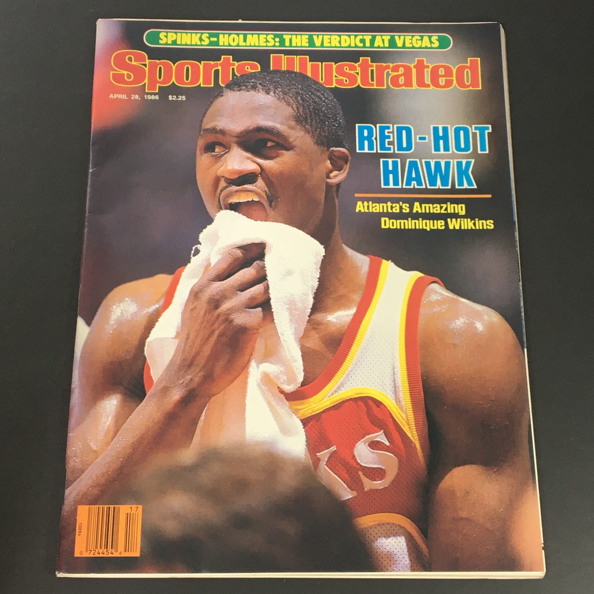 Vintage Sports Illustrated Magazine from April 28, 1986 featuring Dominique Wilkins on the cover. The cover highlights Wilkins, known as the 'Red-Hot Hawk,' showcasing his athleticism in an iconic moment. This collectible issue is perfect for sports enthusiasts and vintage magazine collectors.