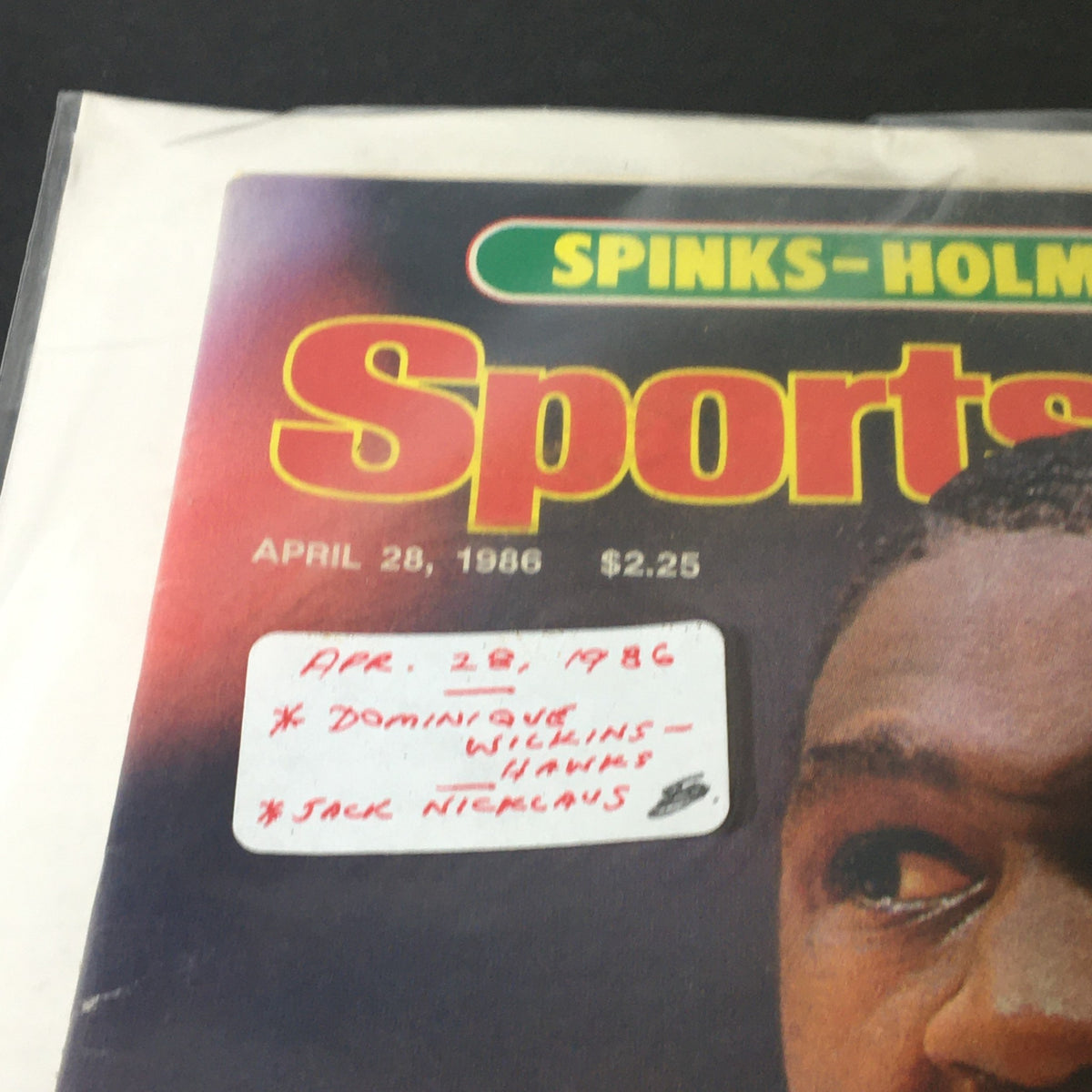 Detailed view of Sports Illustrated magazine dated April 28, 1986, featuring Dominique Wilkins and Jack Nicklaus, emphasizing notable dates and names on the cover.