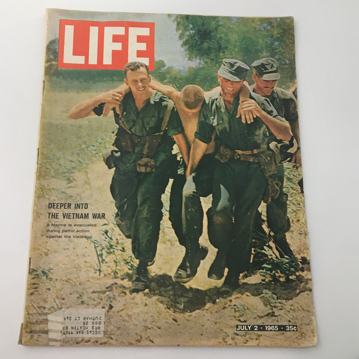 Cover of the vintage Life Magazine from July 2, 1965, titled 'Deeper Into The Vietnam War' featuring a Marine evacuation scene. The cover highlights the Vietnam conflict with soldiers carrying a fellow Marine, illustrating the bravery and dedication of those serving during that era.