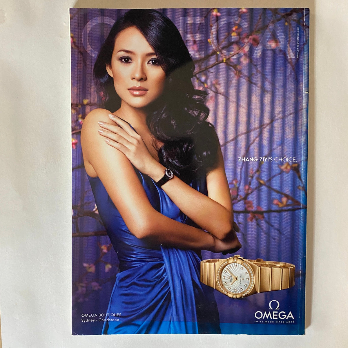 Advertisement featuring actress Zhang Ziyi in a blue dress showcasing an Omega watch, from the Harper's Bazaar Australia Magazine January 2010.