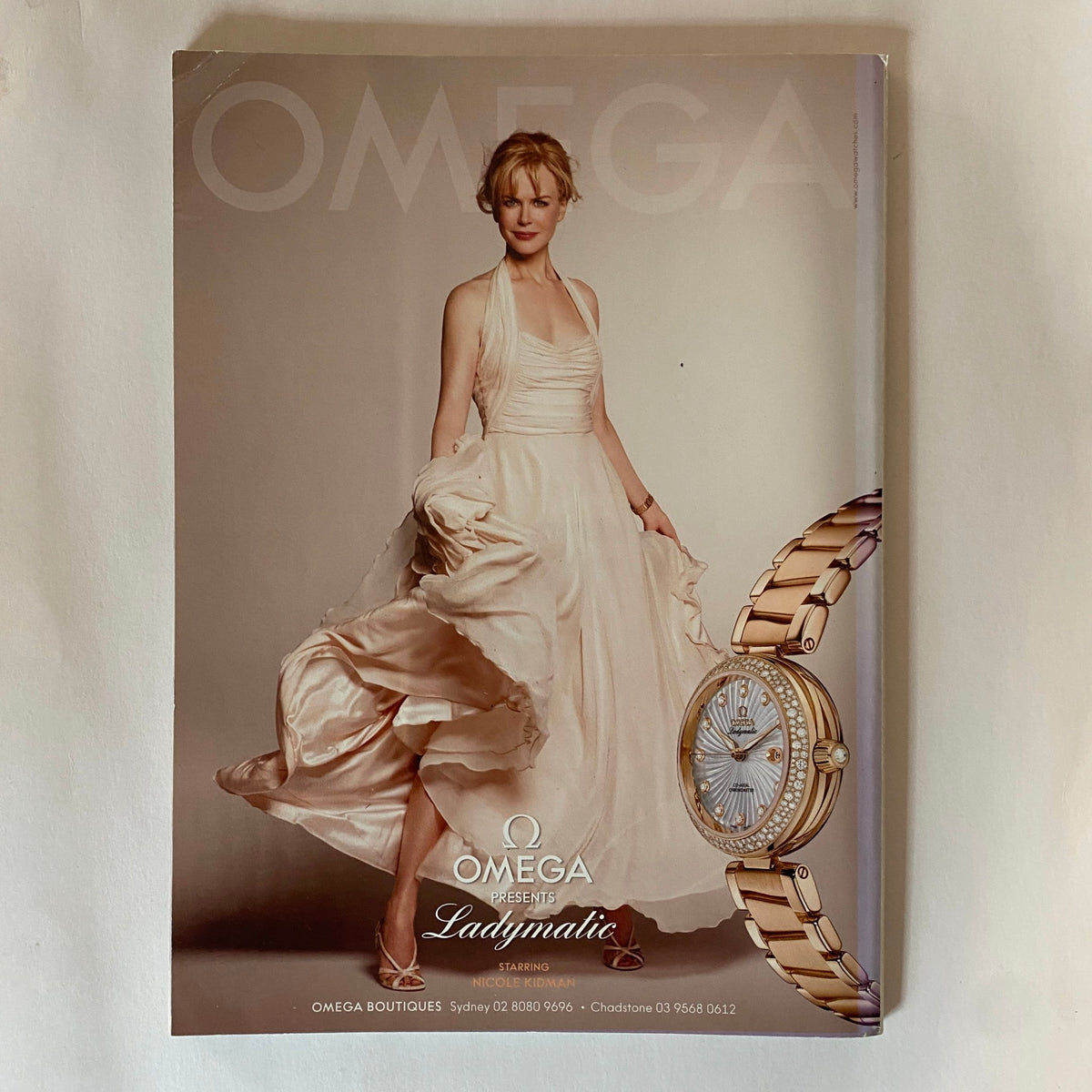 Cover of the Omega Ladymatic advertisement featuring a model in an elegant dress, combining fashion with luxury watch promotion, from the Harper's Bazaar Australia Magazine January 2011.