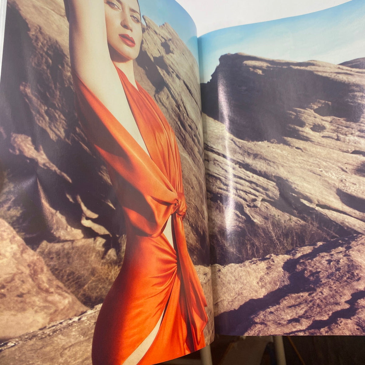 Fashion editorial page from Harper's Bazaar UK January 2011 Magazine showcasing a model in a striking orange gown against a natural rock backdrop, emphasizing modern fashion aesthetics.