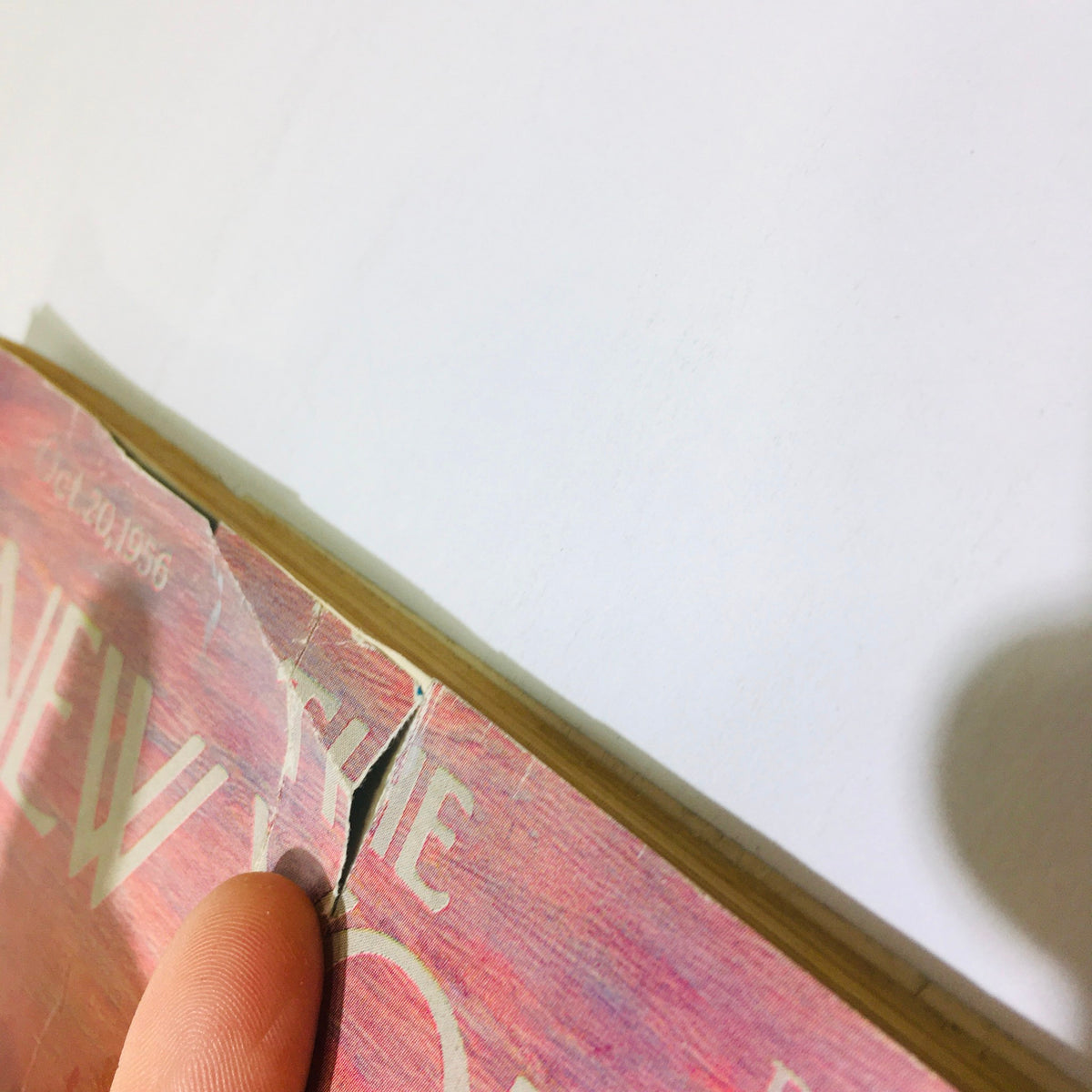 Close-up of the edge of The New Yorker Magazine October 20 1956, showcasing minor damage, including a tear, highlighting its vintage condition and collectible nature.