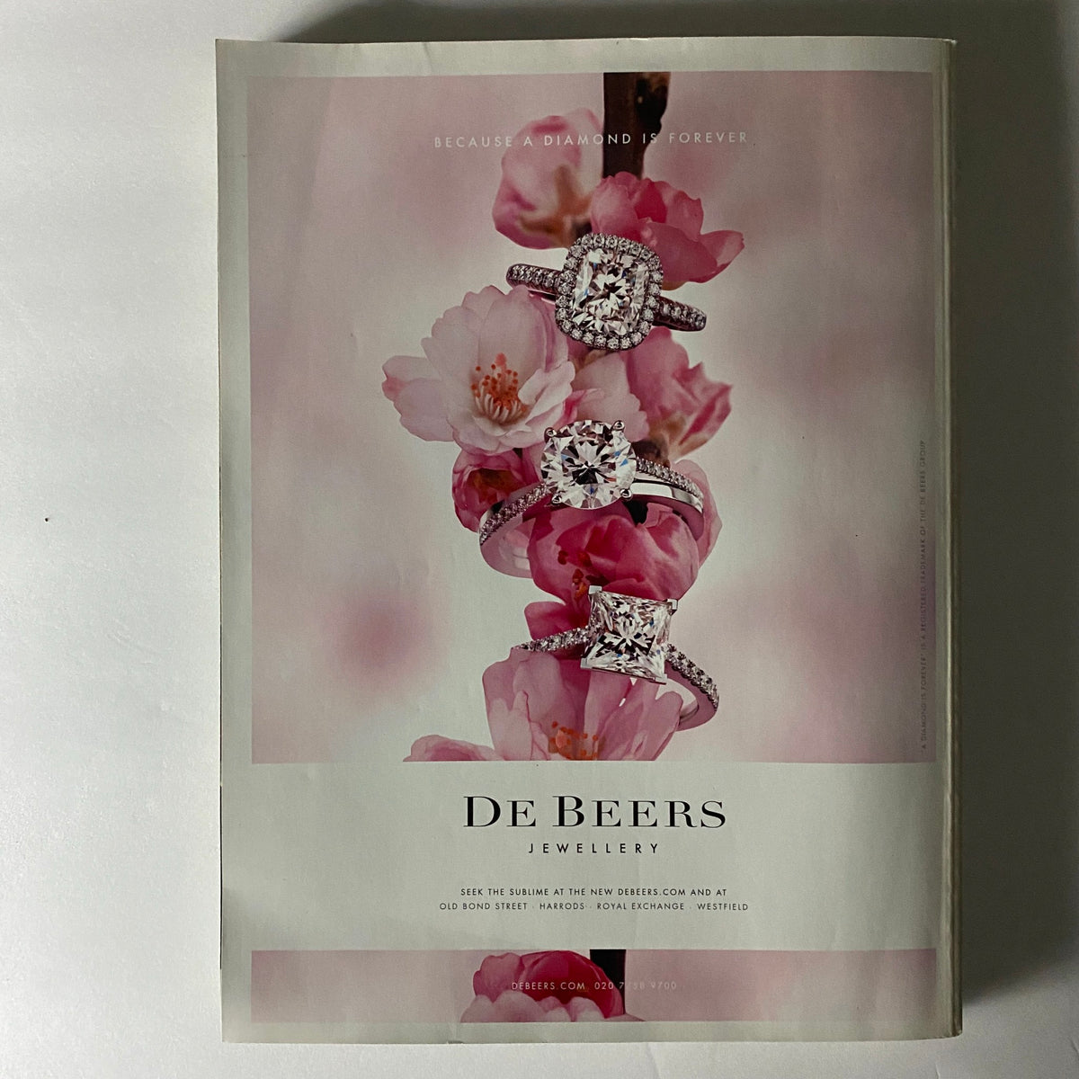 Advertisement from Harper's Bazaar UK Magazine September 2011 for De Beers Jewellery, showcasing diamond rings against a floral backdrop.