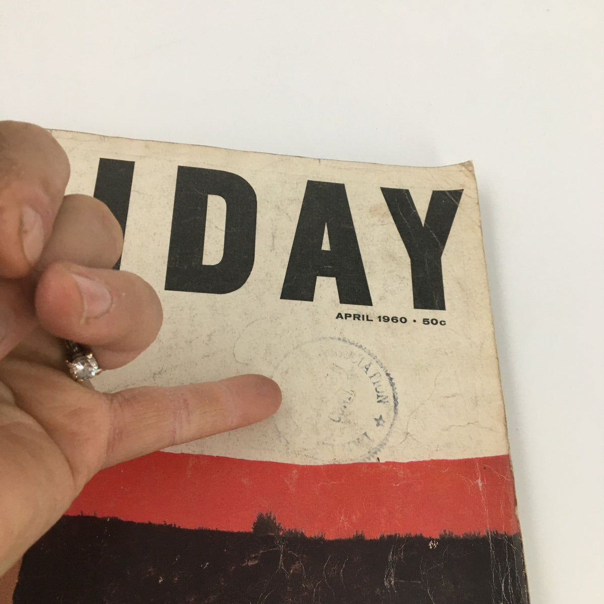Close-up of the VTG Holiday Magazine April 1960 cover showing the embossed stamp and details, highlighting its vintage character.