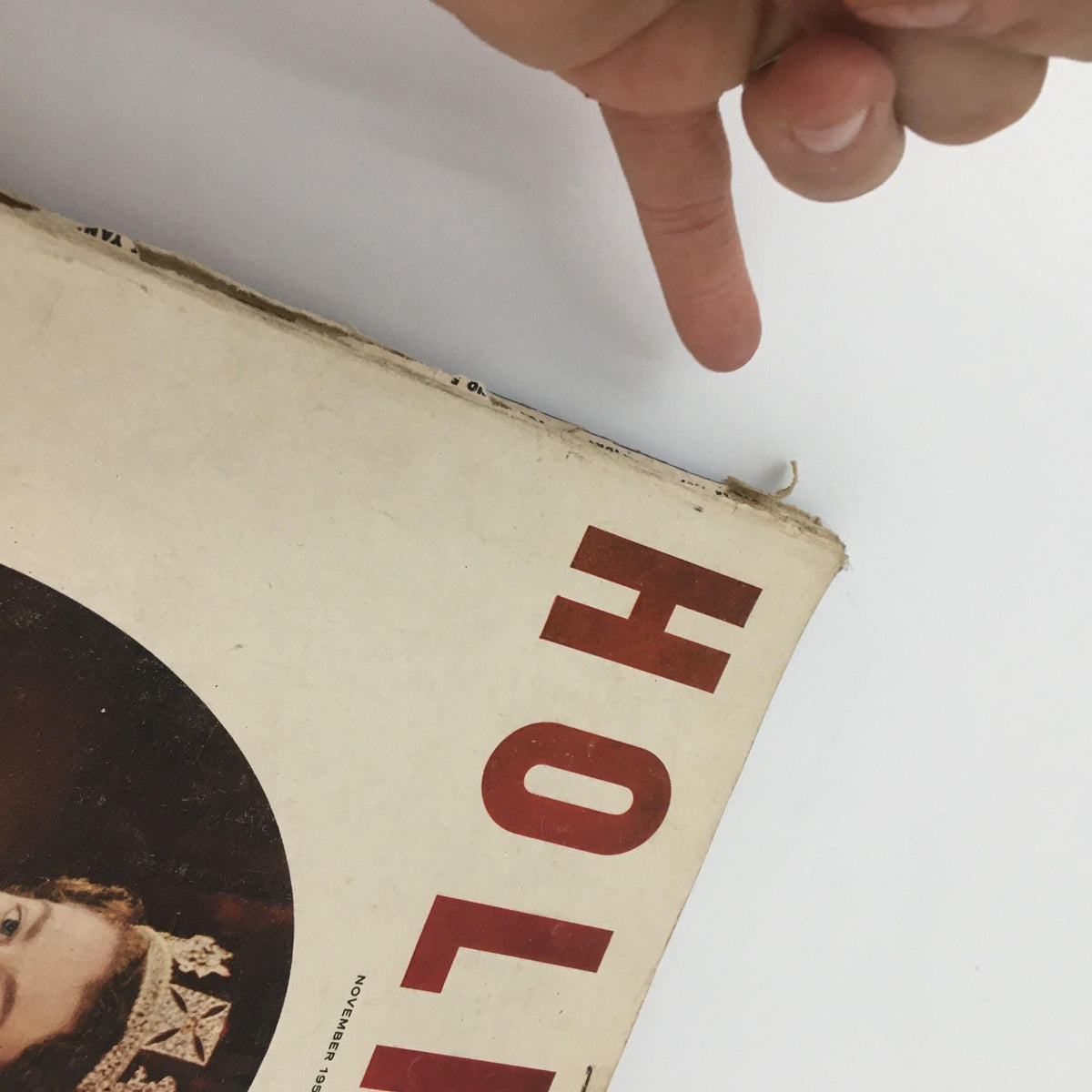 Close-up of the cover edge of VTG Holiday Magazine November 1957 Queen Elizabeth Cover, showing minor wear and imperfections.