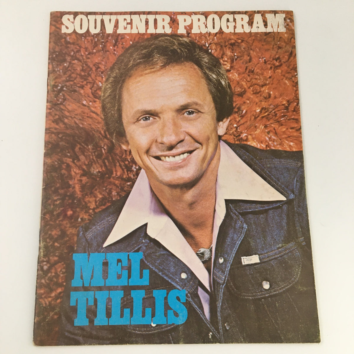 Vintage 1976 Mel Tillis Souvenir Program featuring a portrait of Mel Tillis smiling in denim attire, showcasing country music history.