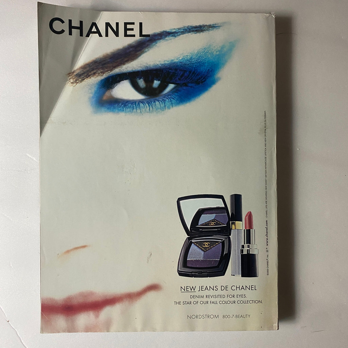 Advertisement page from Elle Magazine September 2003 for Chanel, featuring a striking eye makeup look with 'NEW JEANS DE CHANEL' products.