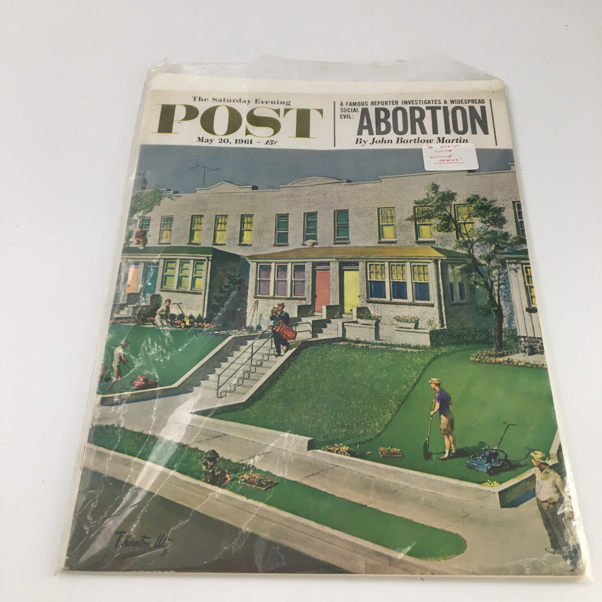 Cover of The Saturday Evening Post from May 20, 1961, showcasing 'A Visit with Willie Mays.' The magazine is encased in protective plastic, highlighting the suburban scene with people engaging in yard work.