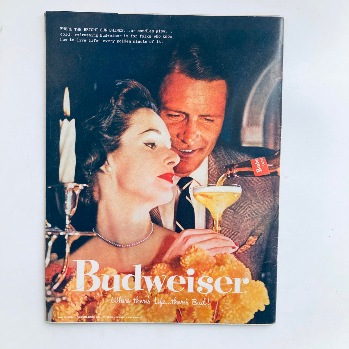 Vintage Budweiser advertisement from the mid-20th century, highlighting a romantic scene with elegant couple and iconic branding.