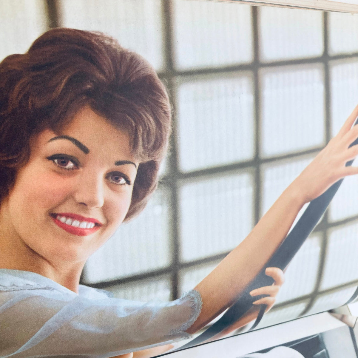 Playmate Ann Davis smiling while holding a steering wheel, featured in the Vintage Playboy Magazine September 1960 as Playmate of the Month.