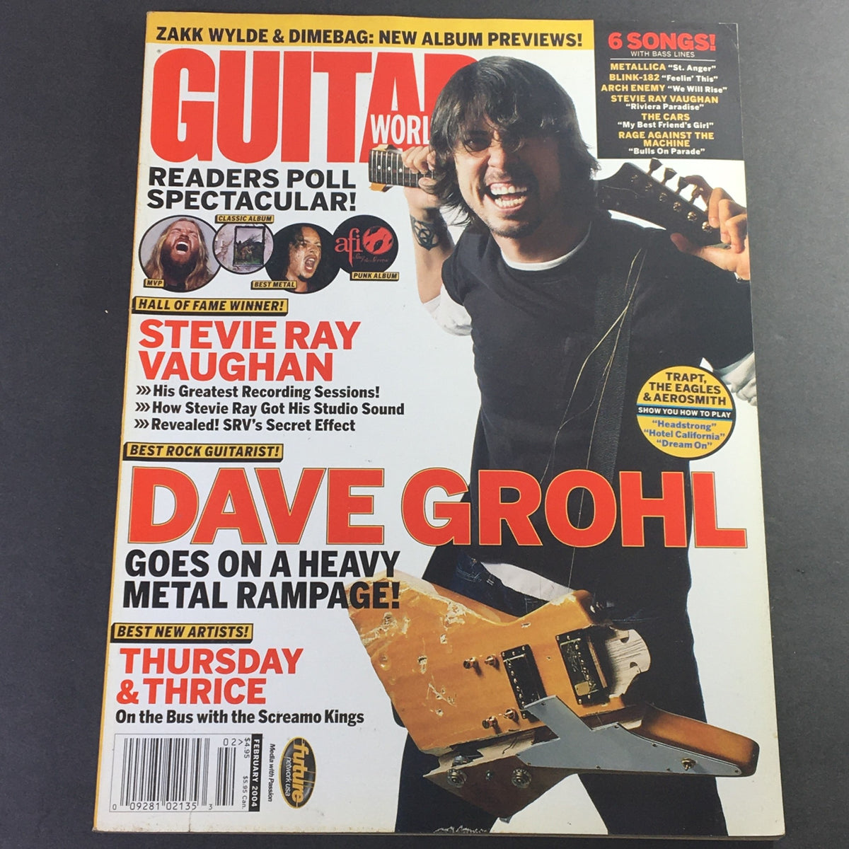 Guitar World Magazine February 2004 featuring Dave Grohl on the cover, showcasing his guitar and an energetic pose. Includes highlights about Stevie Ray Vaughan and upcoming album previews.