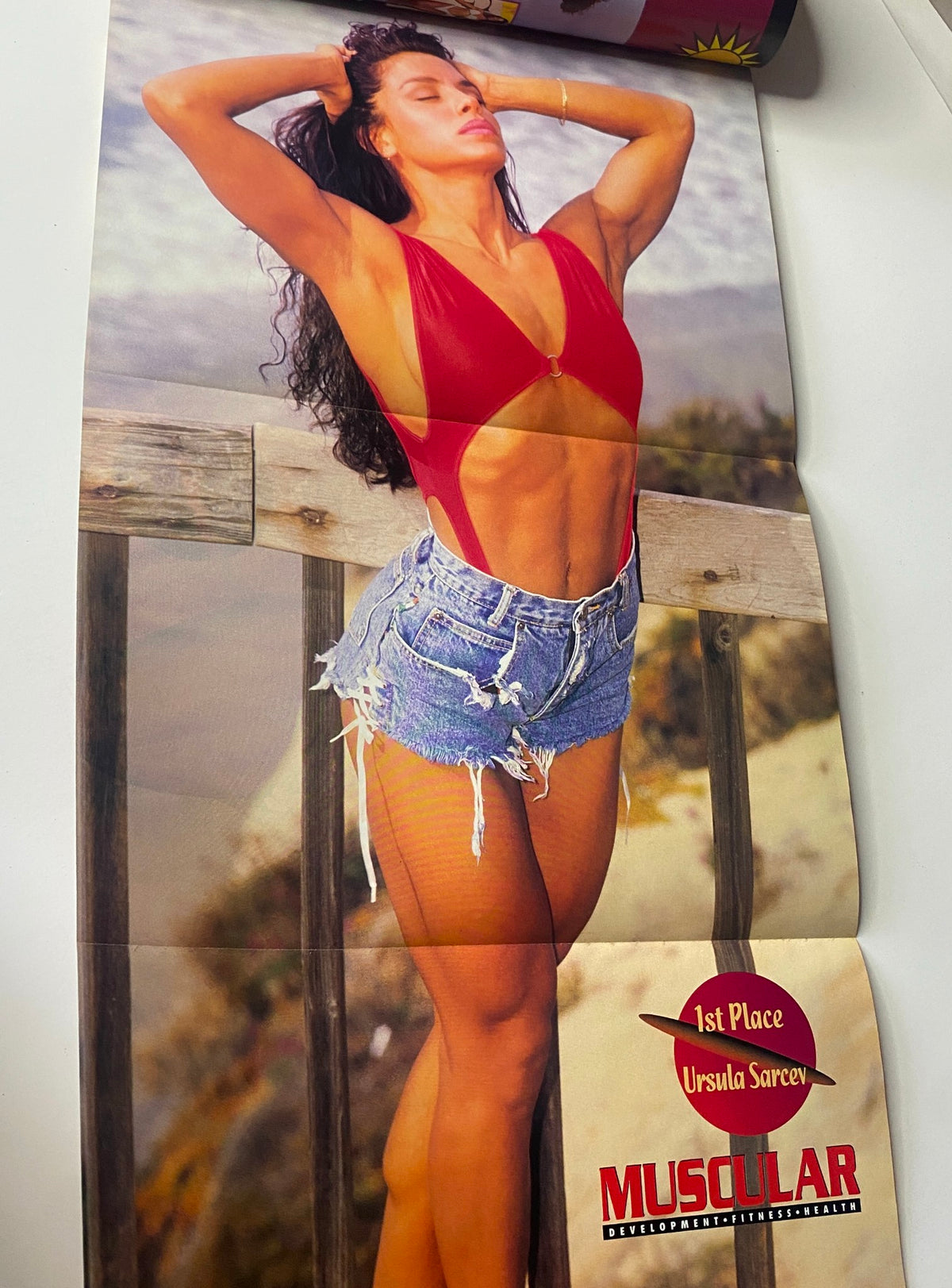 Fold-out poster from Muscular Development Magazine July 1994 showcasing Ursula Sarcev, emphasizing her physique and beauty in a vibrant swimsuit.