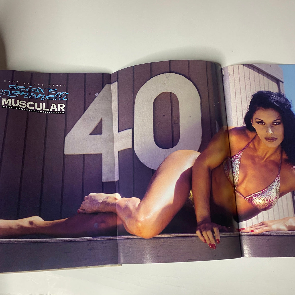 A striking double-page spread from Muscular Development Magazine August 1996 showcasing Deidre Pagnanelli in a glimmering bikini, celebrating her return in the fitness world.
