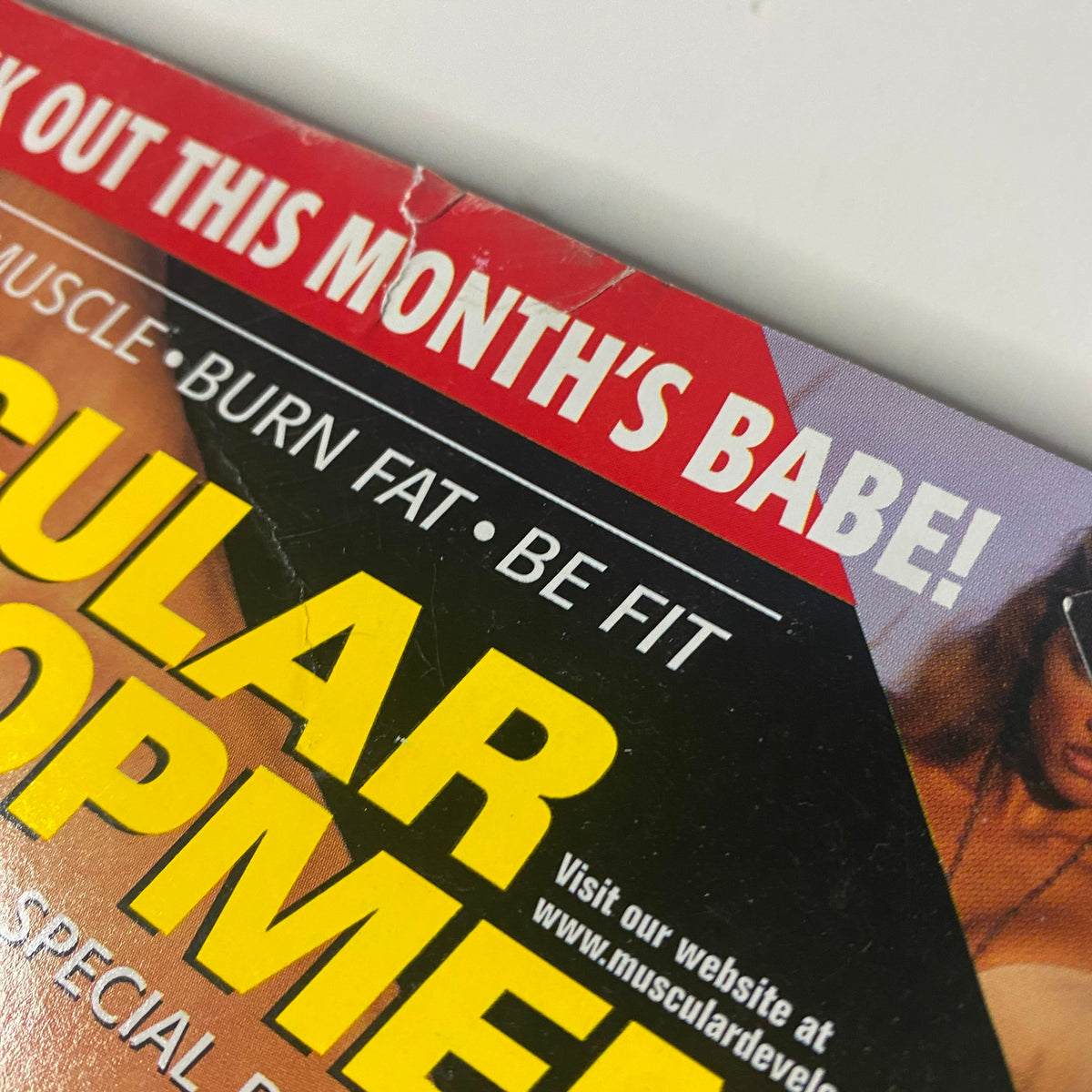 Close-up of the top corner of Muscular Development Magazine March 2001, highlighting the callout 'Check Out This Month's Babe!'
