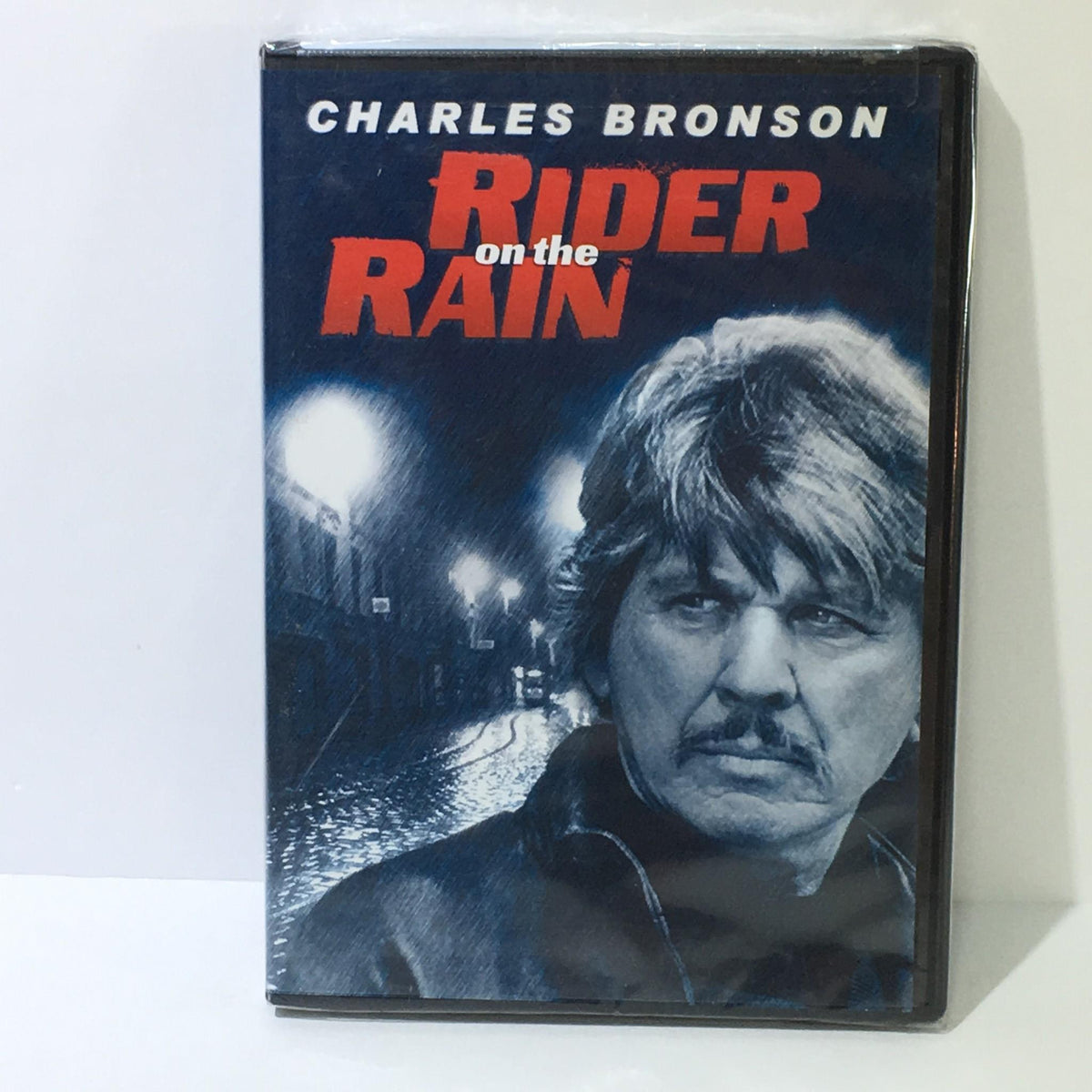 Rider on the Train Charles Bronson DVD cover featuring a portrait of Charles Bronson with a moody aesthetic, emphasizing the title 'Rider on the Rain'.