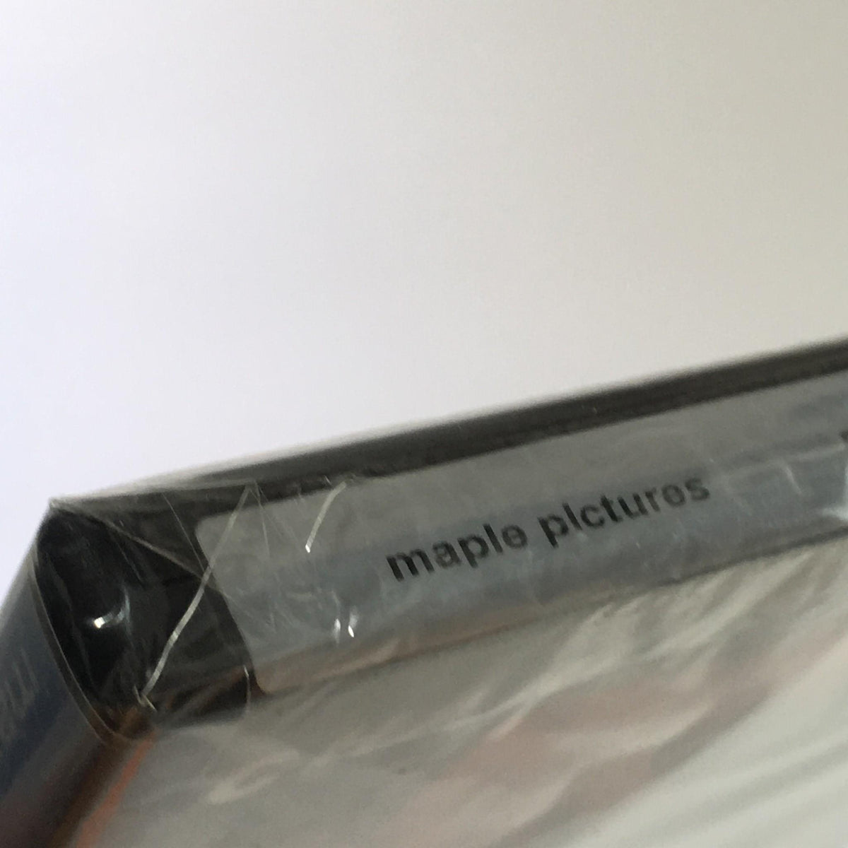 Close-up of the sealed edge featuring 'maple pictures' on the cover of the DVD 'Rider on the Train Charles Bronson'.