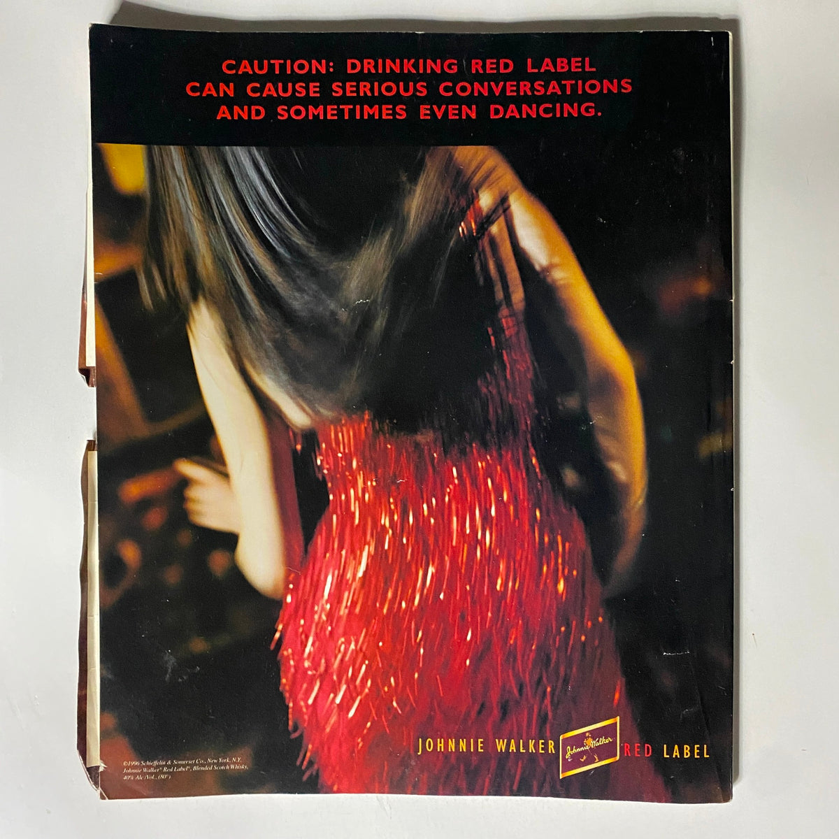 Back cover of George Magazine September 1996 highlighting a striking advertisement for Johnnie Walker Red Label, showcasing an artistic depiction of a woman in a red fringe outfit.