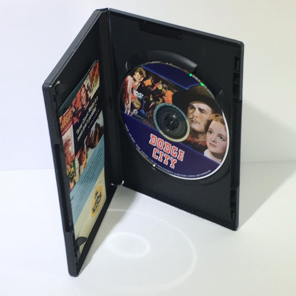 Open DVD case of Errol Flynn Dodge City, displaying the DVD with cover art featuring Errol Flynn, Olivia de Havilland, and Ann Sheridan.