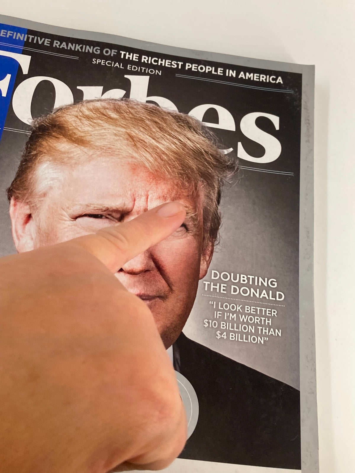 Close-up of Donald Trump's image on the Forbes Magazine October 19 2015 cover, emphasizing his quote about wealth.