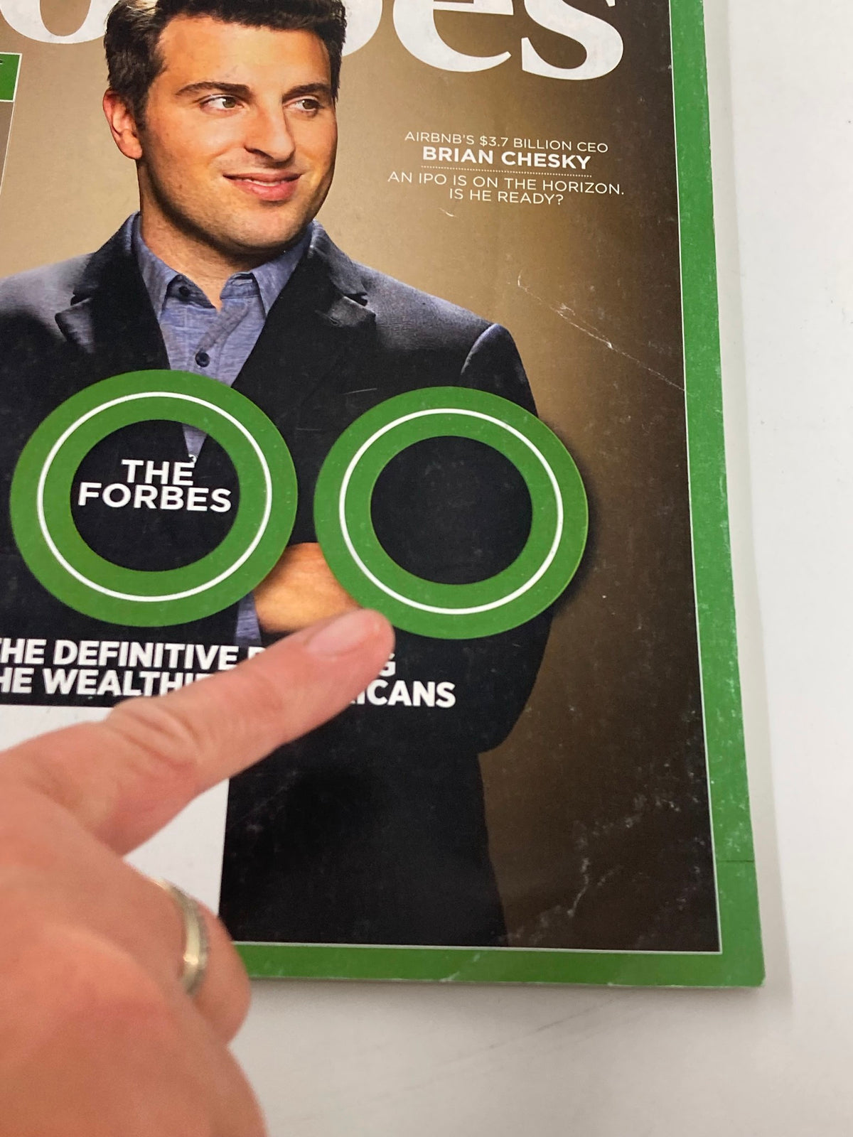 Close-up of Forbes Magazine cover highlighting The Forbes 400 with an emphasis on Brian Chesky, discussing his role in the travel industry and wealth rankings.