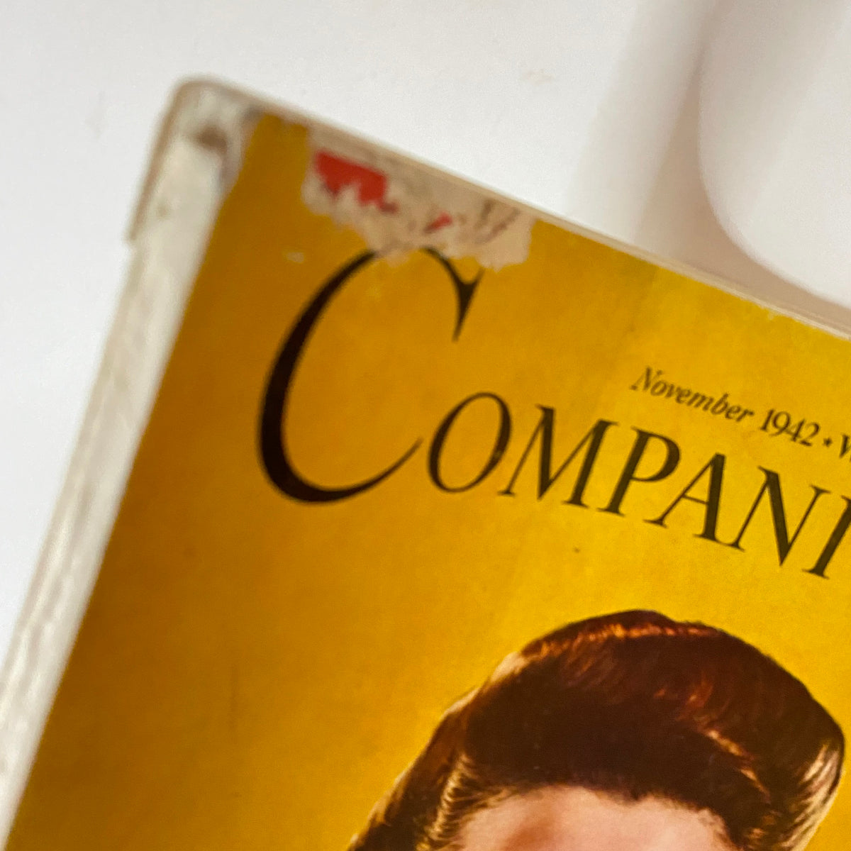 Close-up of the top corner of Woman's Home Companion Magazine November 1942, highlighting the vintage logo and wear typical of its age.