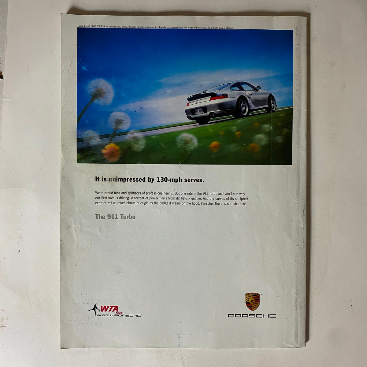 Back cover of Tennis Magazine July 2004 featuring an advertisement for the Porsche 911 Turbo, emphasizing its performance and connection to tennis with a focus on speed.