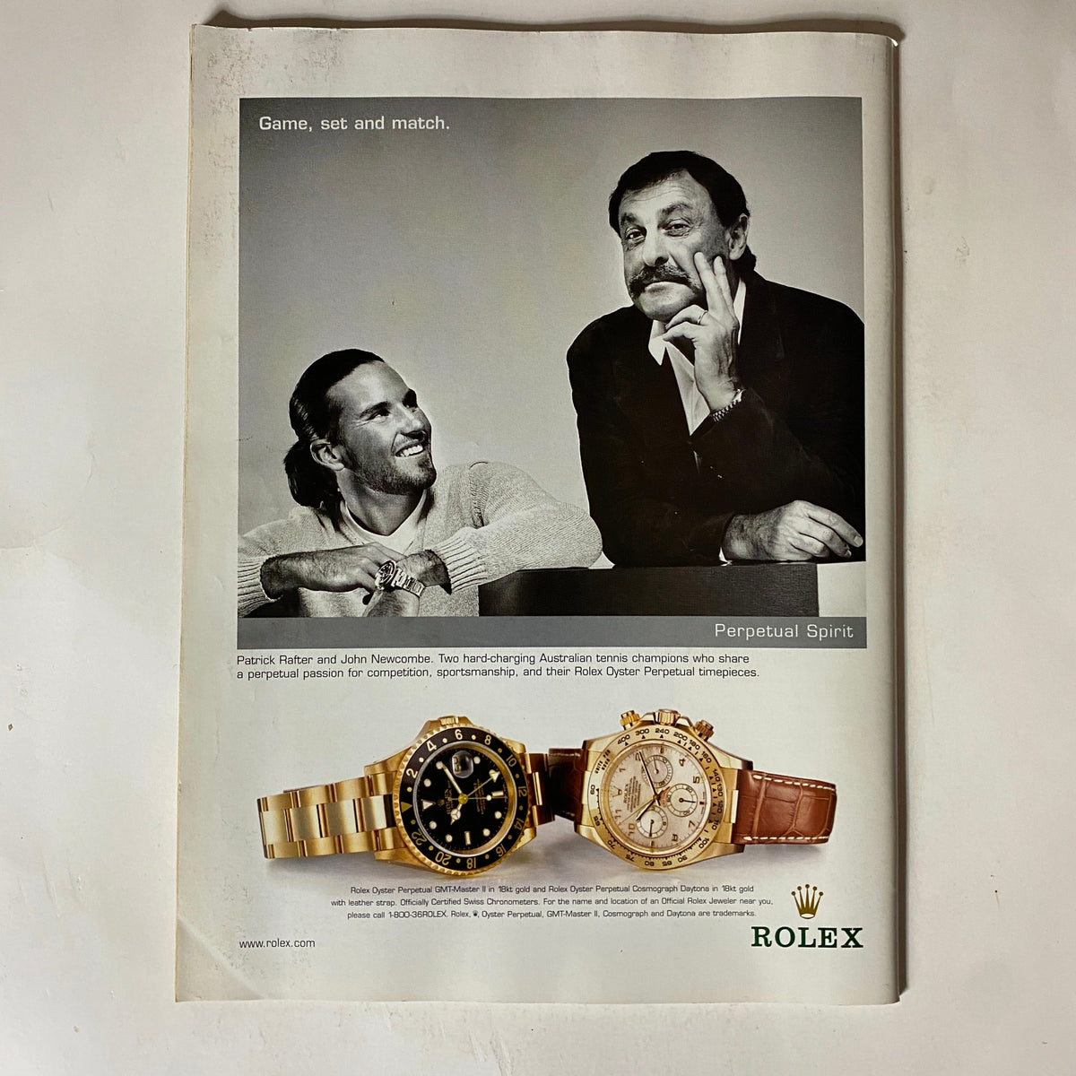 Advertisement for Rolex watches featuring tennis champions Patrick Rafter and John Newcombe, illustrating the connection between luxury sports and professionalism in tennis.