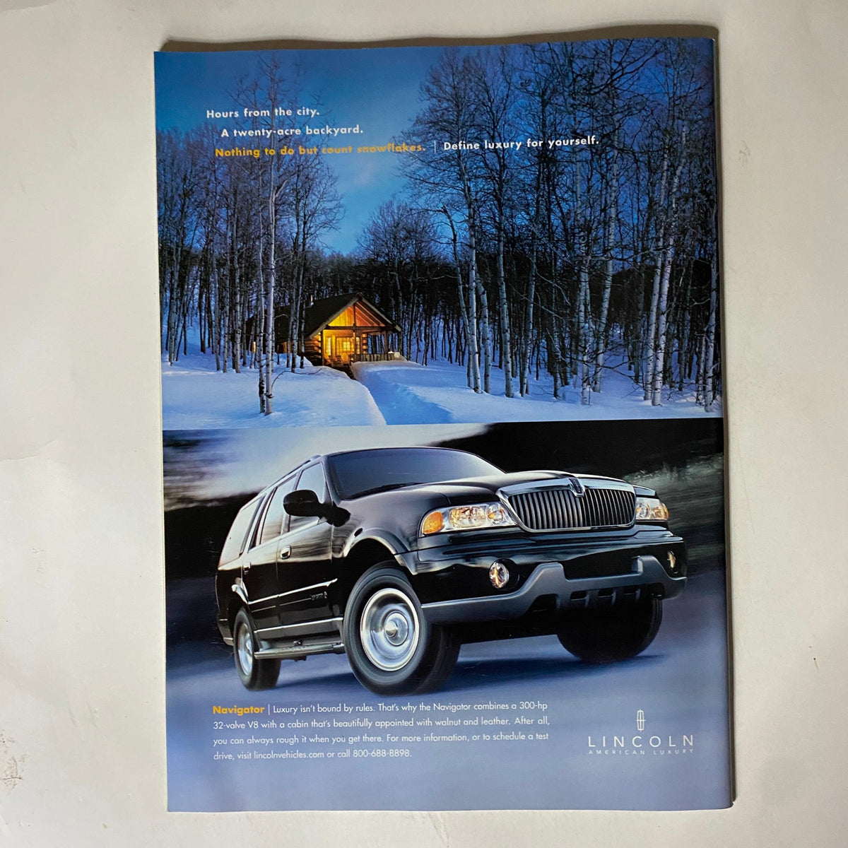 Back cover advertisement from Tennis Magazine February 2001 featuring a luxury vehicle, highlighting a serene winter scene with a cabin backdrop.