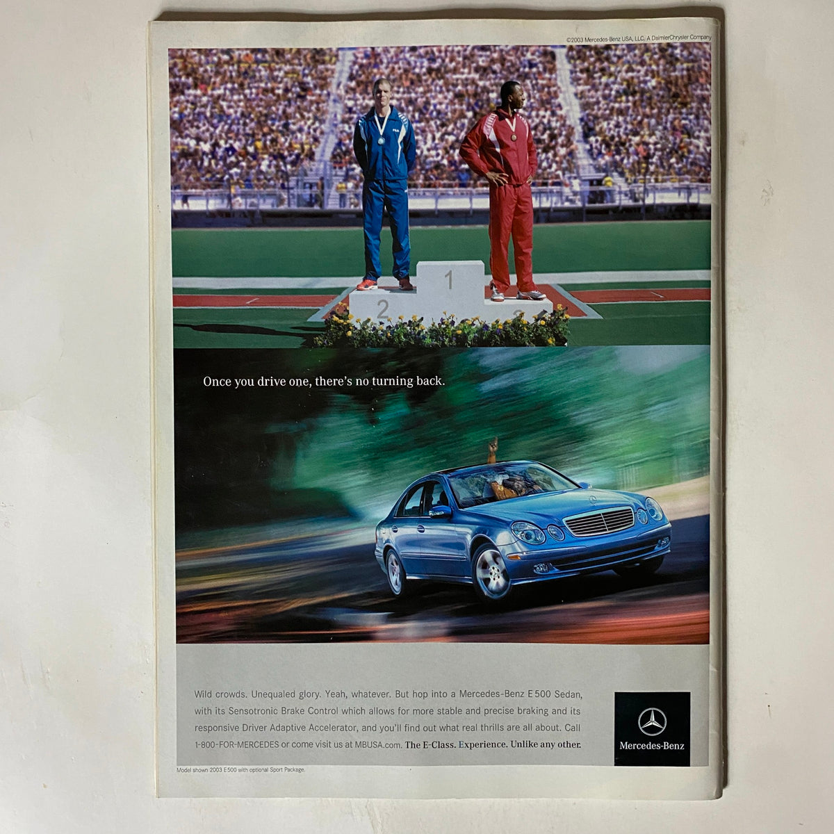 Advertisement in Tennis Magazine April 2003 featuring a Mercedes-Benz E 500 Sedan, emphasizing luxury and performance in a sports context.