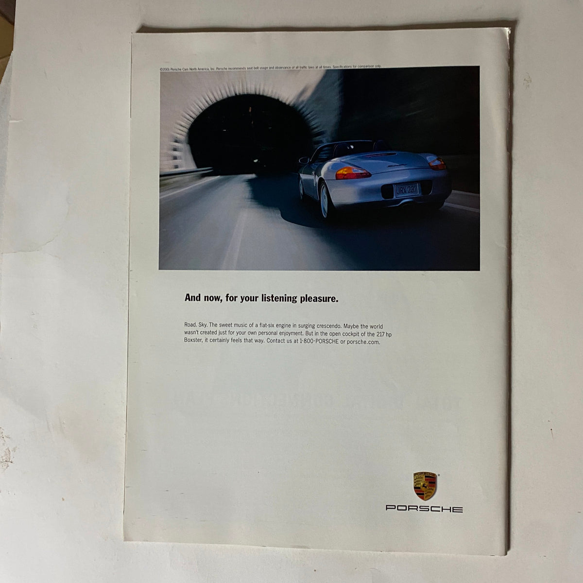 Back cover of Tennis Magazine February 2002 showcasing a Porsche advertisement with a sleek car positioned inside a tunnel, promoting luxury and performance.
