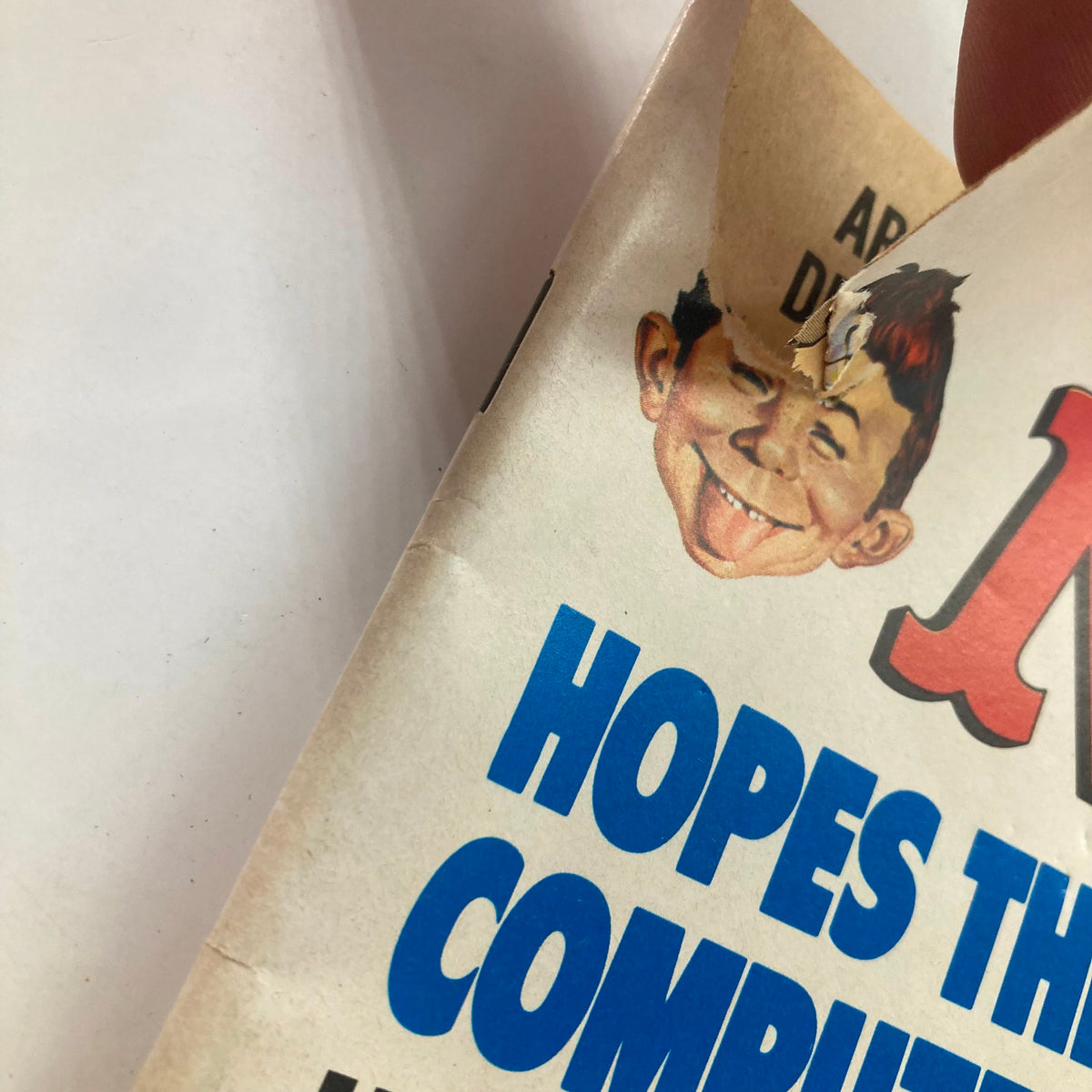 Close-up of Mad Magazine April 1978 No. 198 cover showing the iconic Alfred E. Neuman character and a tear on the page. This vintage magazine humorously critiques modern technology.