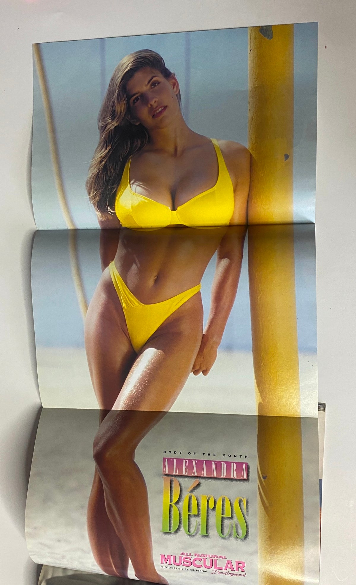 Pull-out poster from Muscular Development Magazine July 1997 featuring Alexandra Béres in a yellow bikini, representing fitness and beauty in bodybuilding.