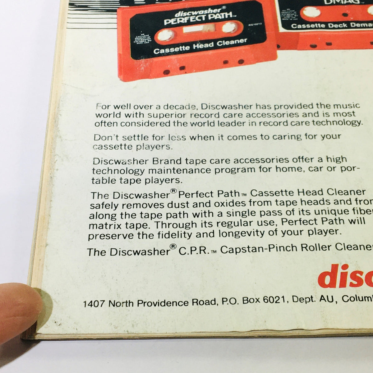 Close-up of the back cover of Audio Magazine May 1984, highlighting the Discwasher cassette head cleaner and its features for maintaining cassette players.