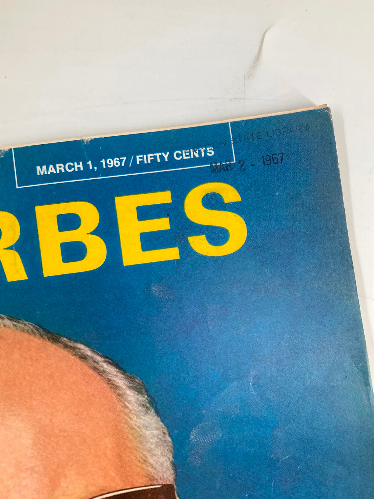 Close-up of the top section of the March 1, 1967 issue of Forbes Magazine, showing the date and price along with the title in bright yellow. Highlights the vintage appeal of this historic publication.