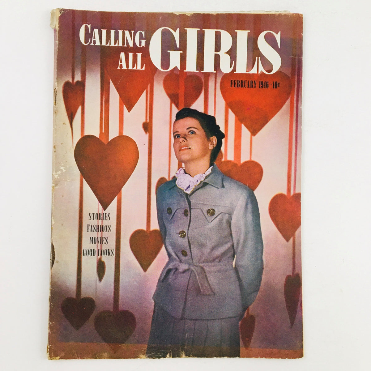 Cover of Calling All Girls Magazine February 1946 featuring a young woman in a stylish outfit against a backdrop of hearts, emphasizing the theme of fashion design.