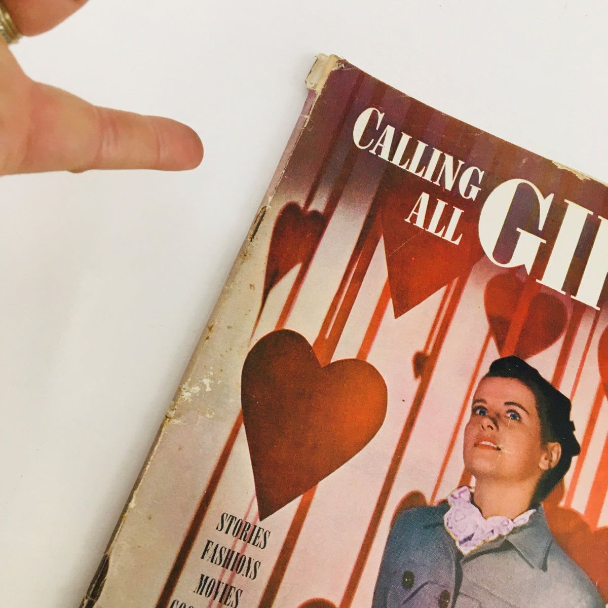 Close-up view of the cover of Calling All Girls Magazine February 1946 showcasing a young woman looking upwards, with decorative hearts in the background.