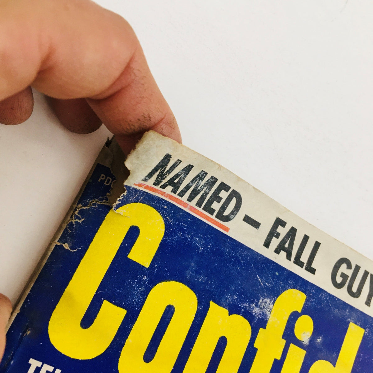 Detail of the spine of Confidential Magazine May 1955, showing wear and historic features with the title prominently displayed.
