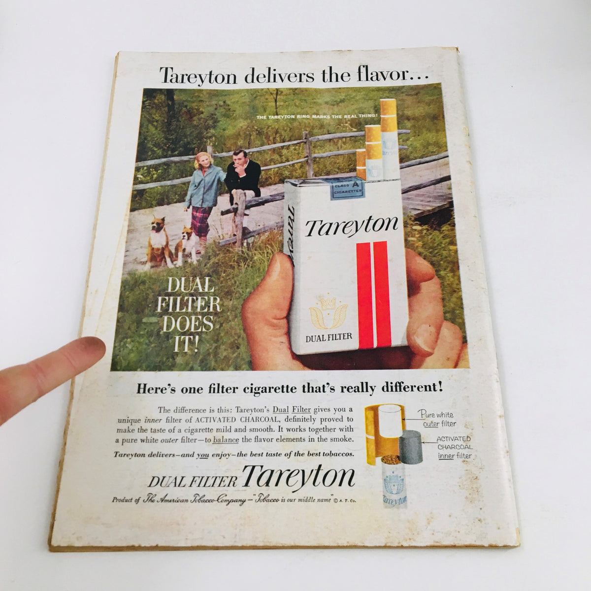 Vintage advertisement featuring Tareyton cigarettes from Newsweek Magazine May 1 1961, showcasing the product's dual filter technology and an outdoor scene with a couple and dogs.