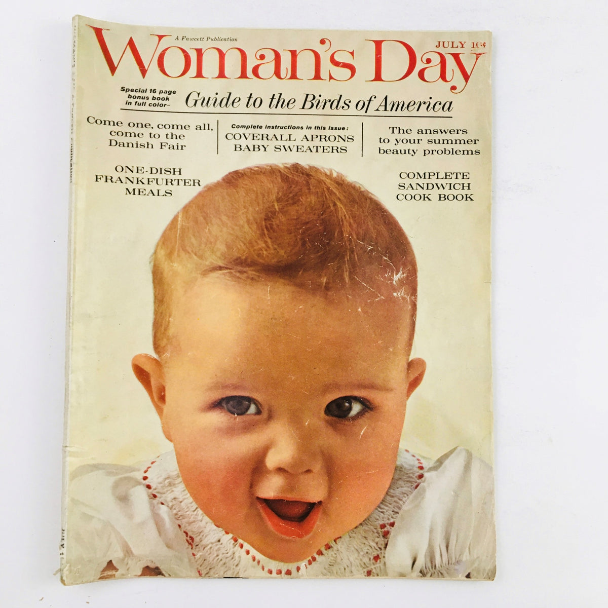 Cover of Woman's Day Magazine July 1963 showcasing a smiling baby with a unique hairstyle, featuring articles on coverall aprons and baby sweaters.