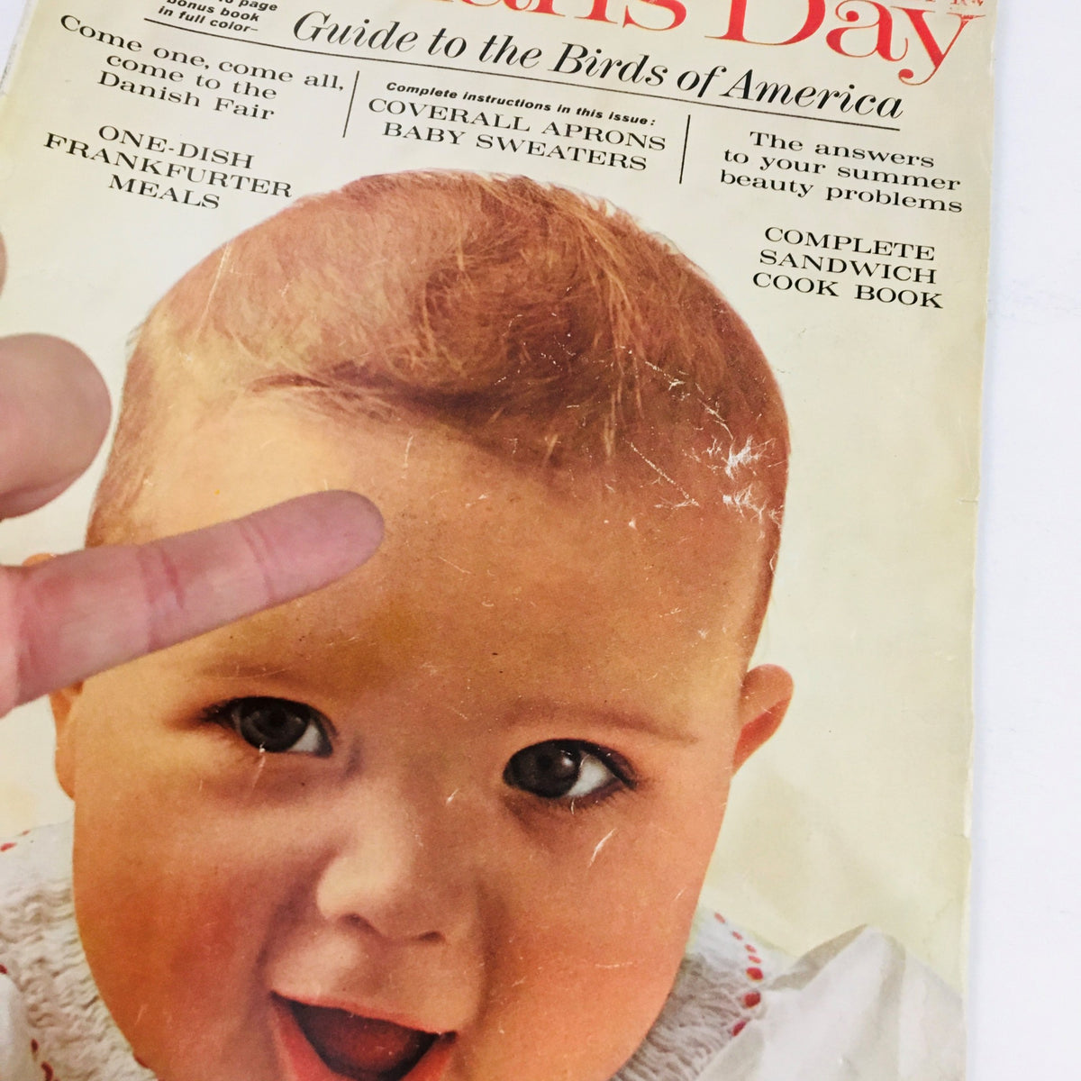 Close-up of the cover of Woman's Day Magazine July 1963, highlighting a charming baby wearing a white dress, with a focus on magazine's title and articles.
